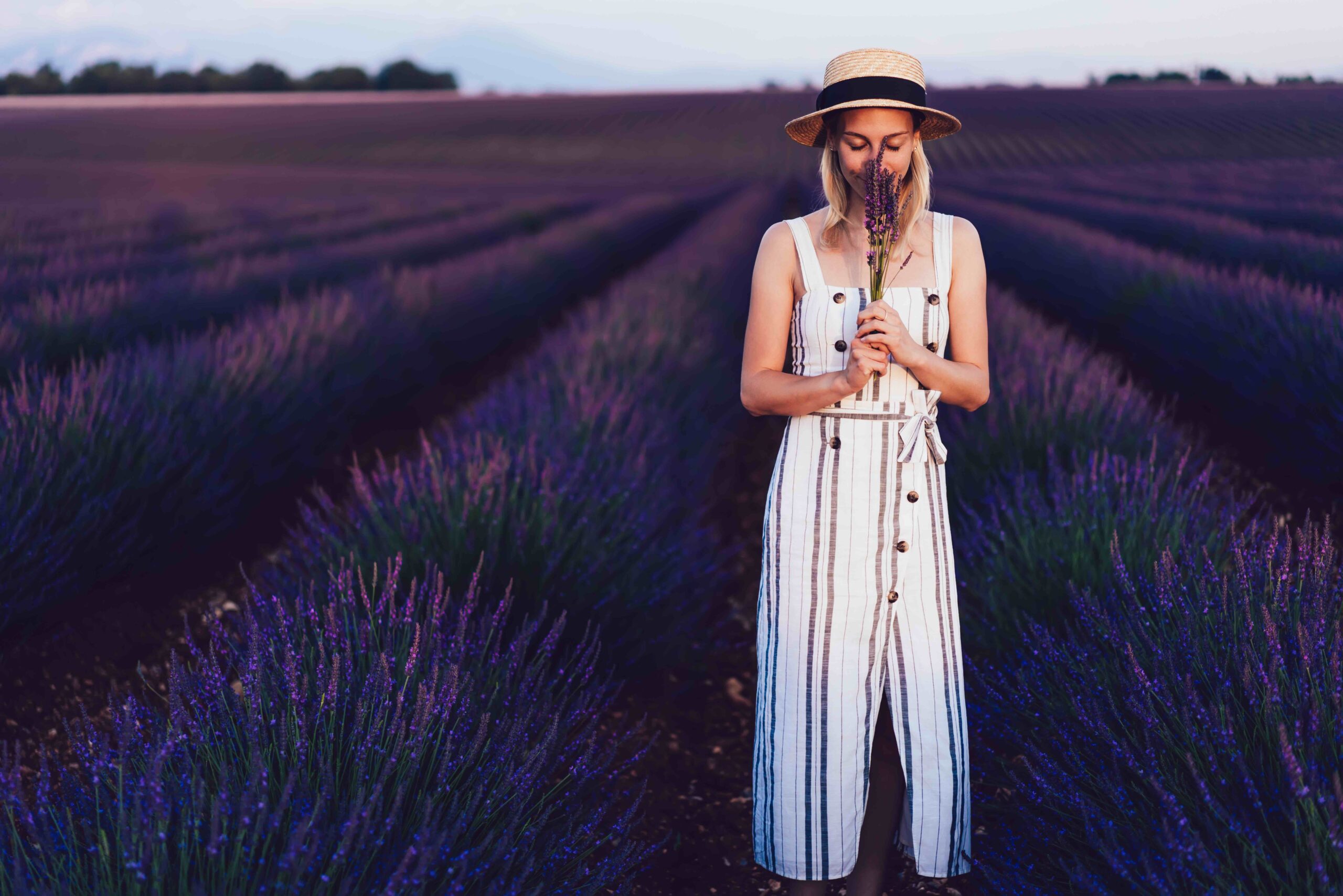 Peaceful woman smelling flower in field